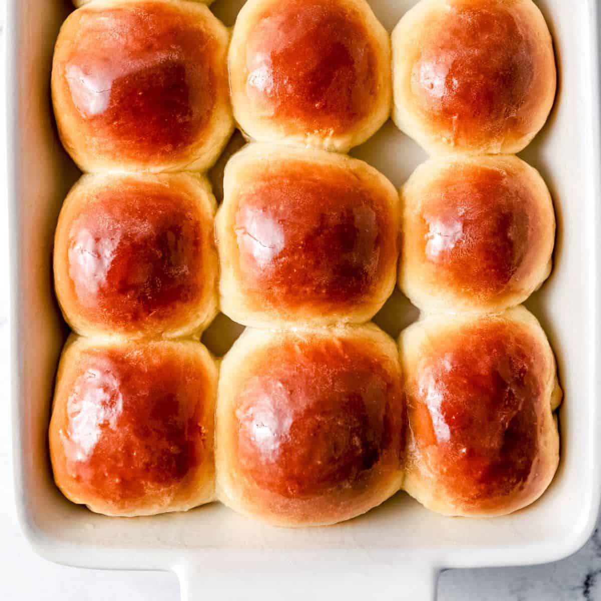 Overhead view of finished rolls in white baking dish.