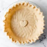 Overhead view of pie crust in glass pie dish.