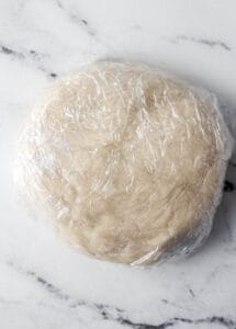 Pie dough wrapped in plastic wrap.