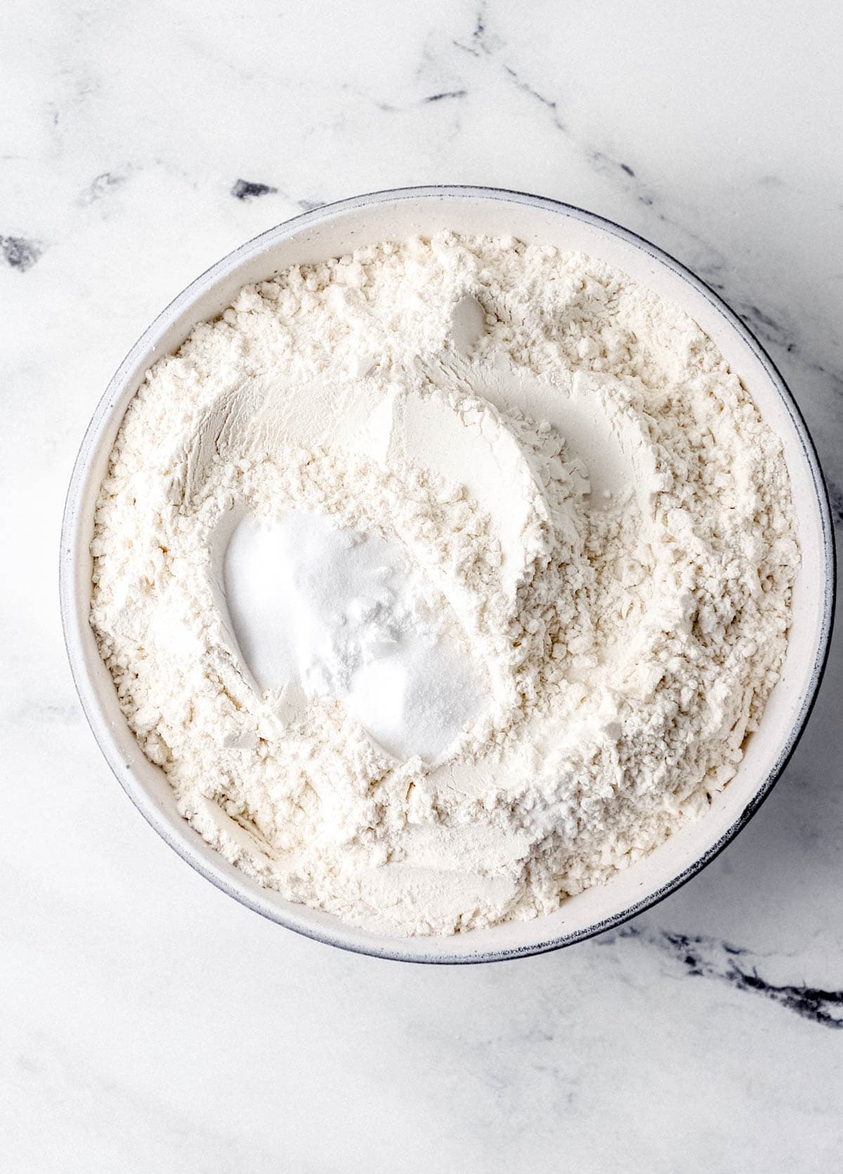 Overhead view of dry ingredients in white bowl. 