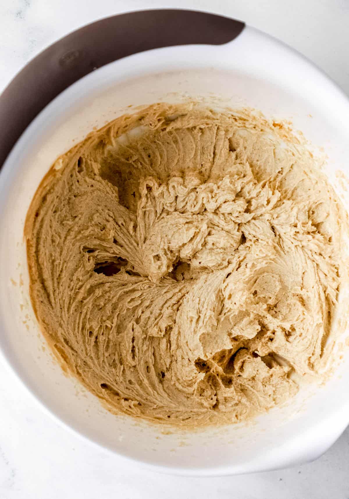 Butter, sugar, and brown sugar combined in large white mixing bowl. 