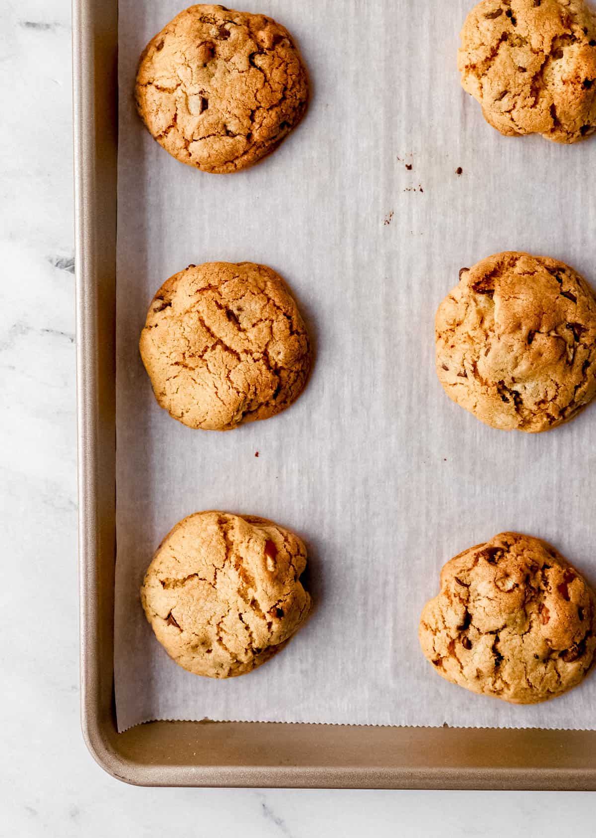 Overhead view of baked cookies on parchment lined baking sheet. 