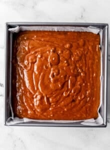 Cake mixture added to parchment lined baking pan.