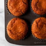 Overhead view of baked muffins in pan with muffin liners.