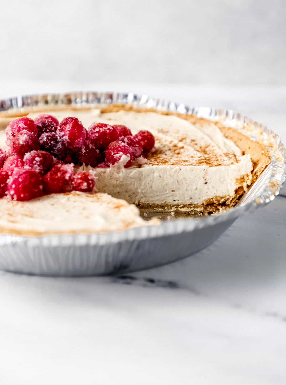 Close up side view of cheesecake with a slice cut out of it. 