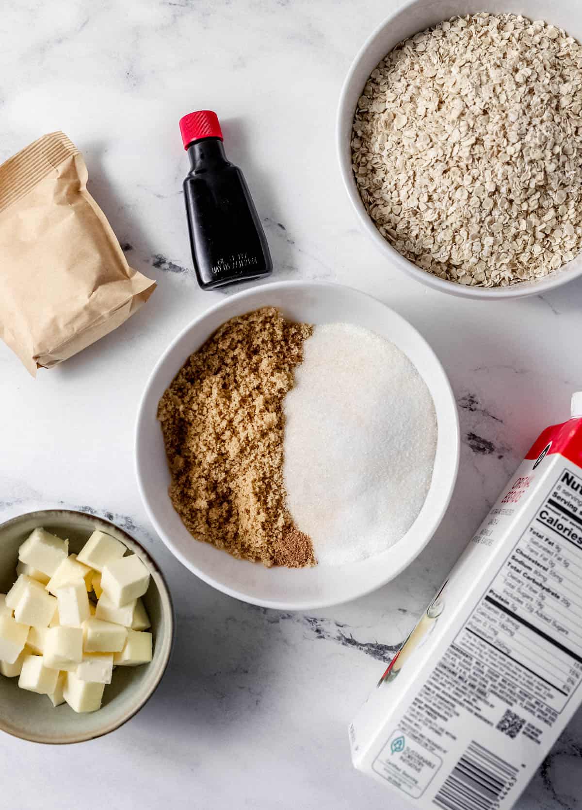 Overhead view of ingredients needed to make cookies on marble surface. 