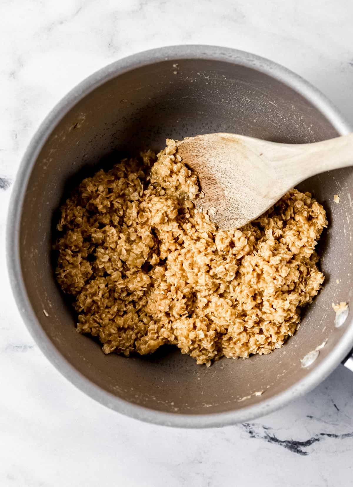 Pudding and oats added to saucepan with the other cookie ingredients with a wooden spoon. 