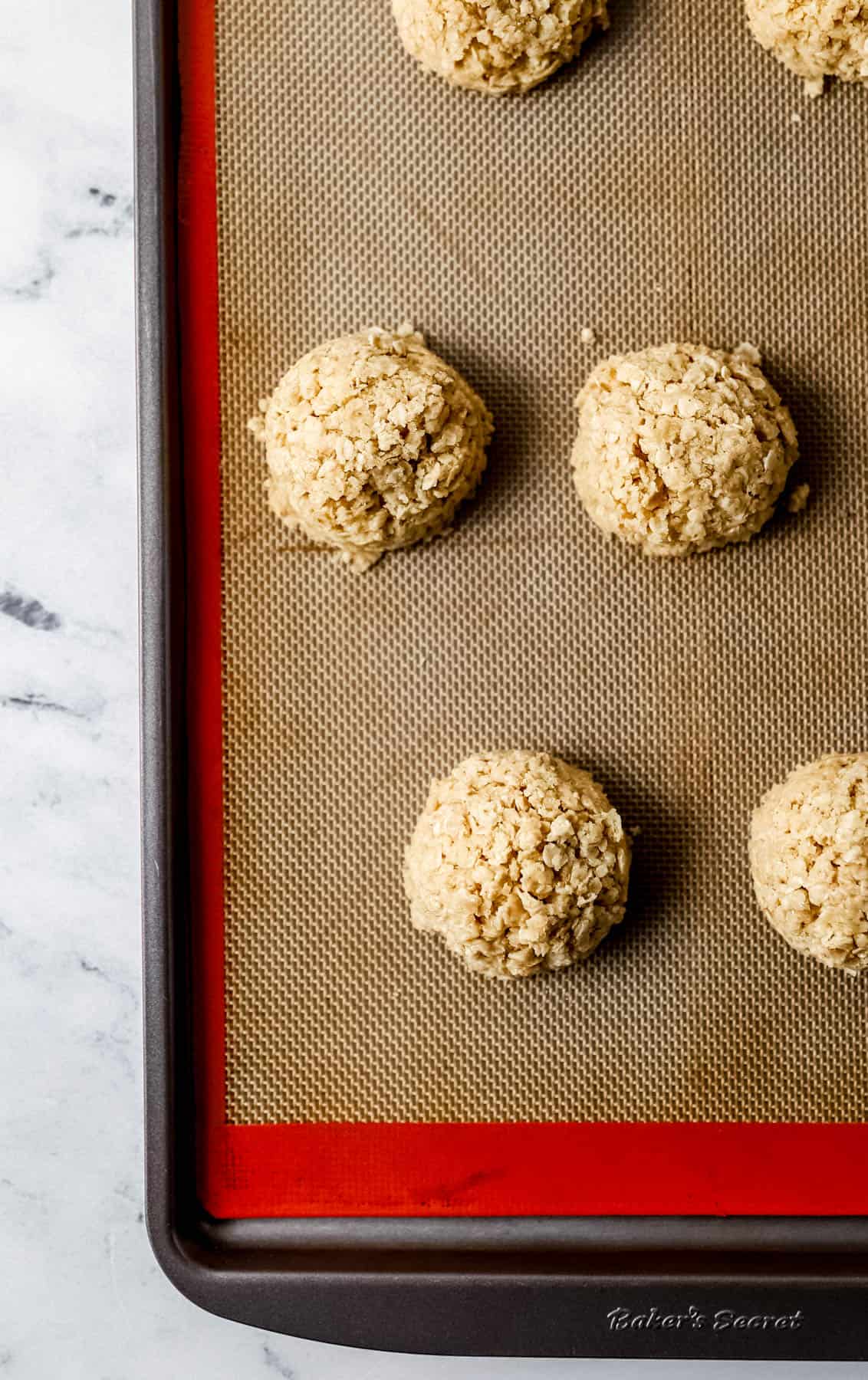 Cookie dough place on baking sheet with non-stick liner. 