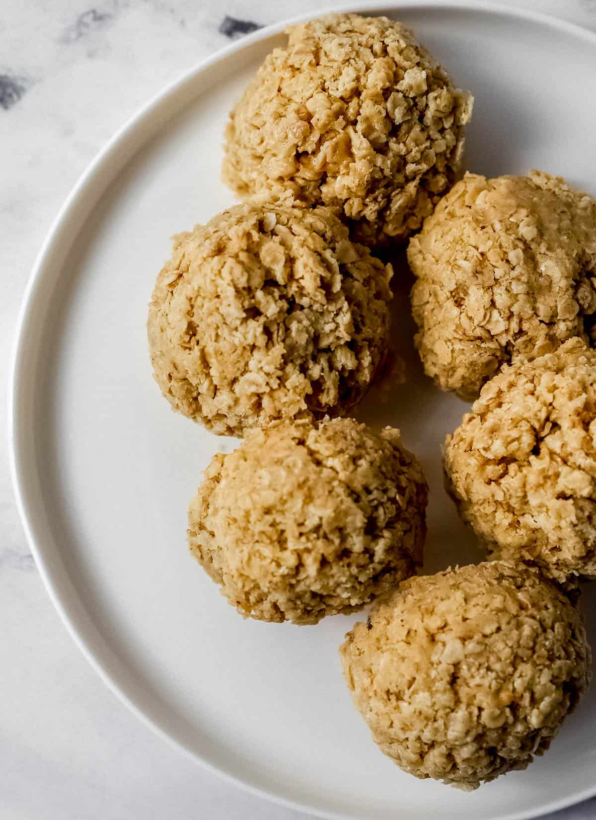 Overhead view of finished cookies on white plate. 