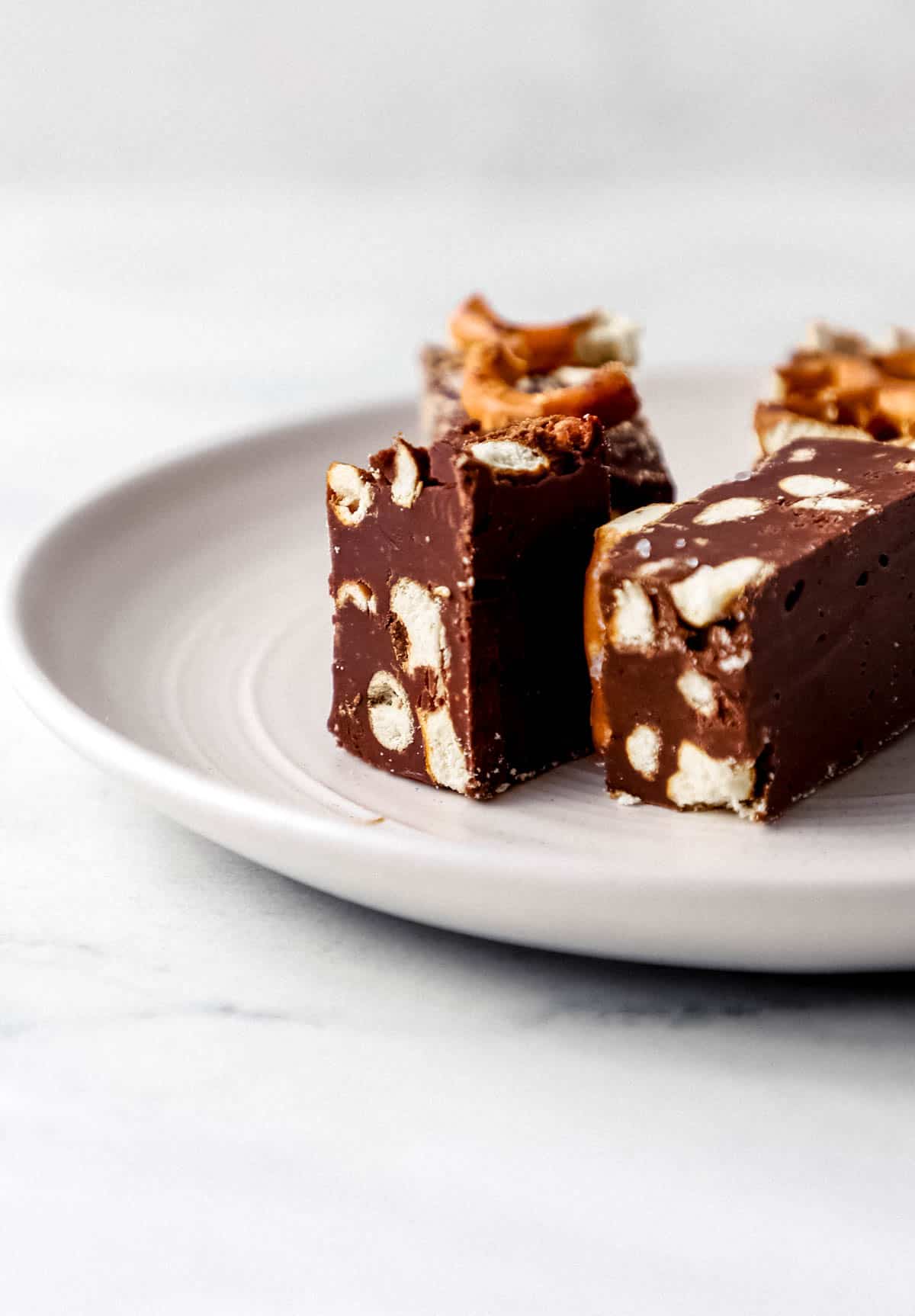 Close up side view of pieces on fudge on a small plate. 