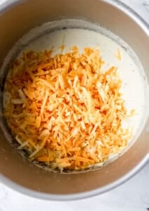 Shredded cheese added to the other ingredients in the large pot.