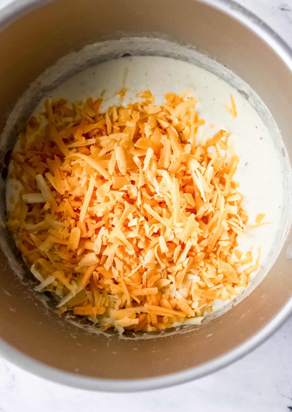Shredded cheese added to stockpot with the other sauce ingredients. 