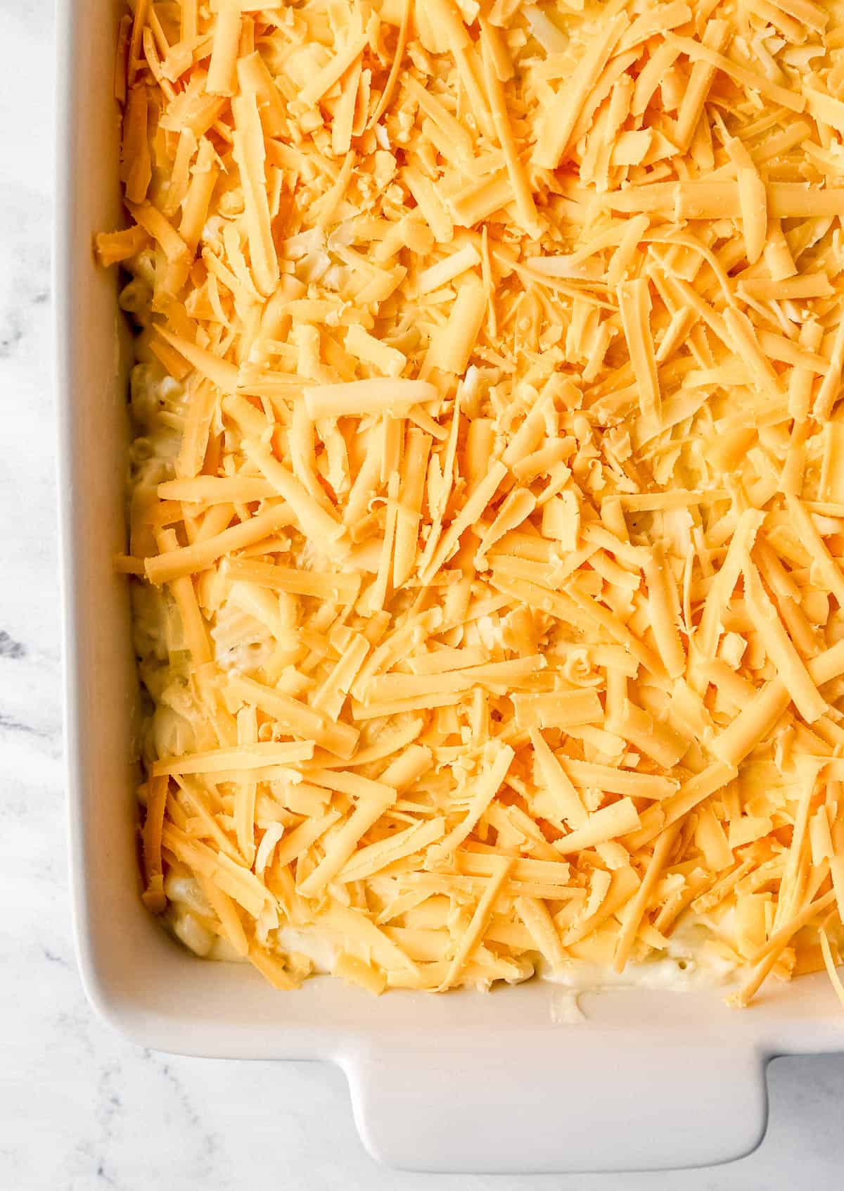Overhead view of unbaked mac and cheese in white baking dish. 