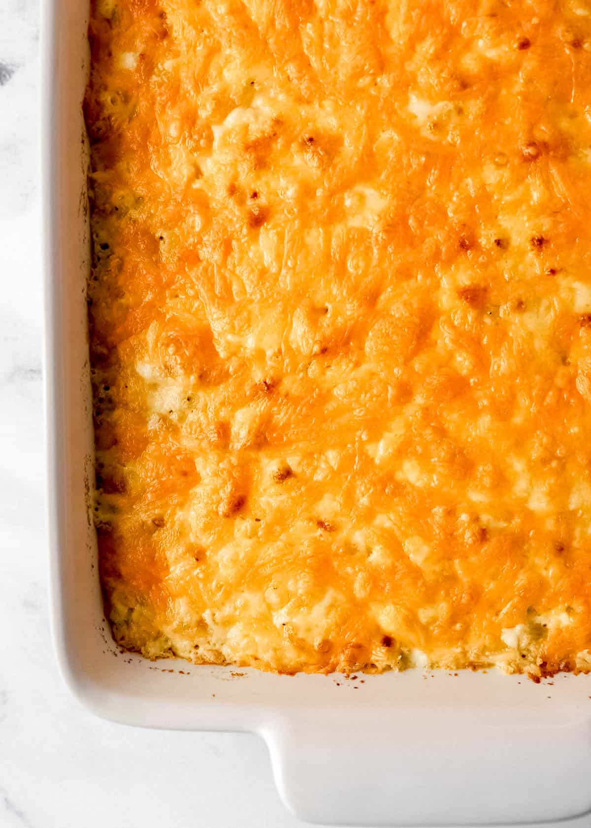 Close up overhead view of baked mac and cheese in white baking dish. 