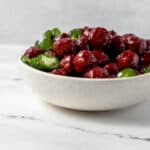Close up side view of meatballs in white bowl.