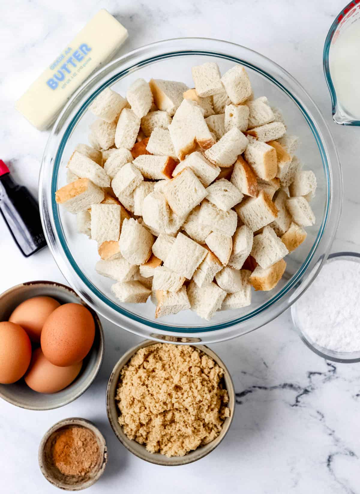 Overhead view of ingredients needed to make french toast in separate bowls. 