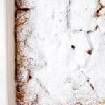French toast in baking dish topped with powdered sugar.