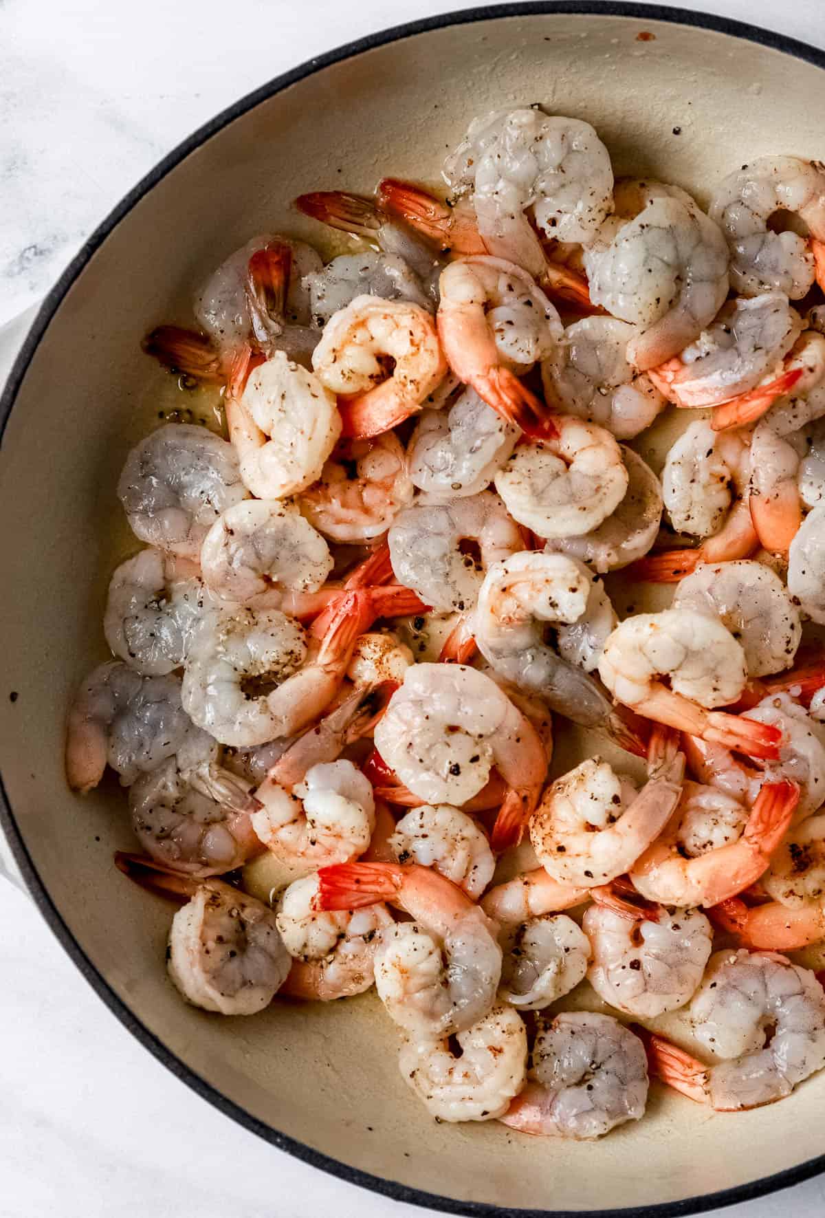Seasoned shrimp and butter in braiser pan. 
