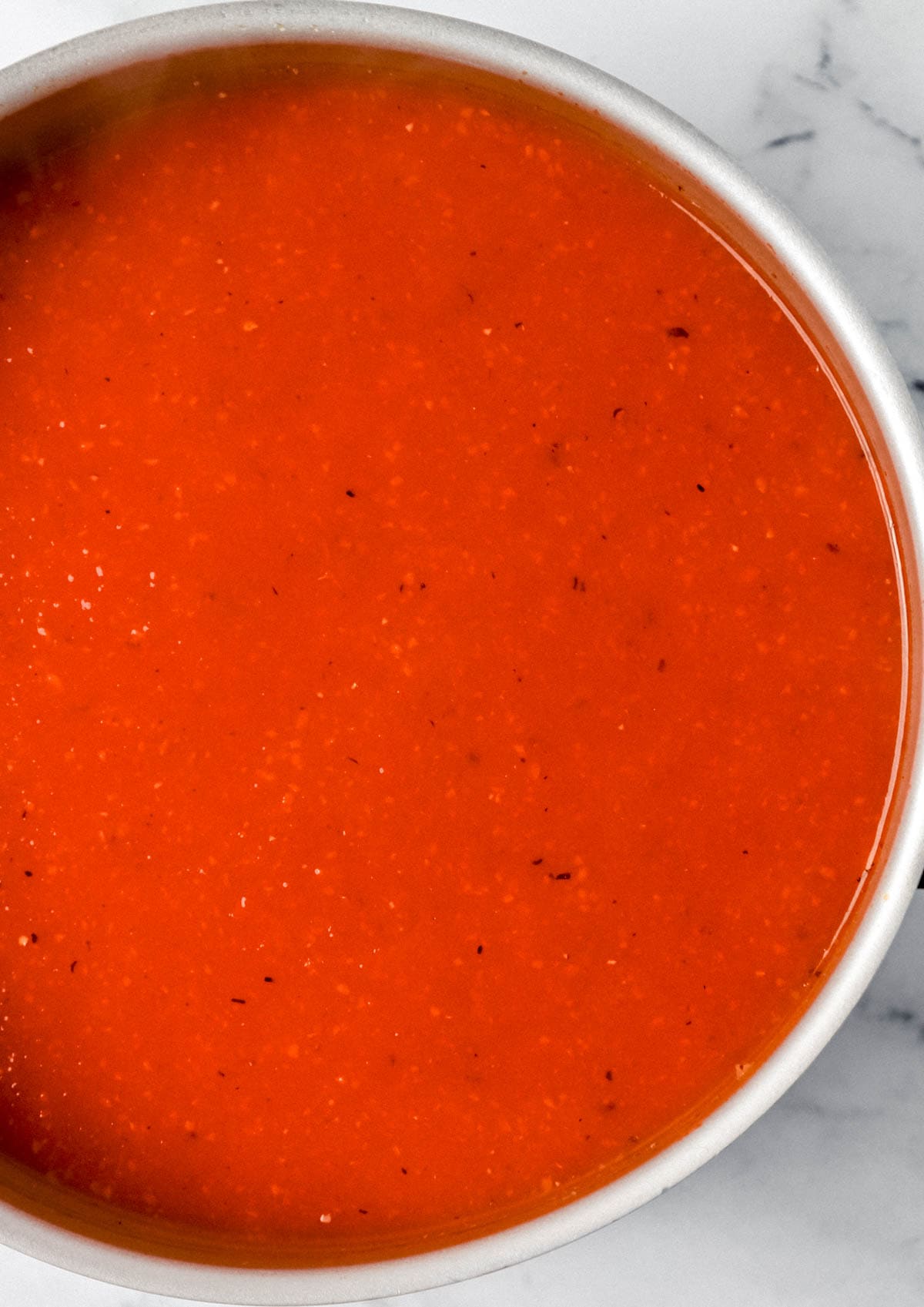 Overhead view of finished tomato soup in large pot. 