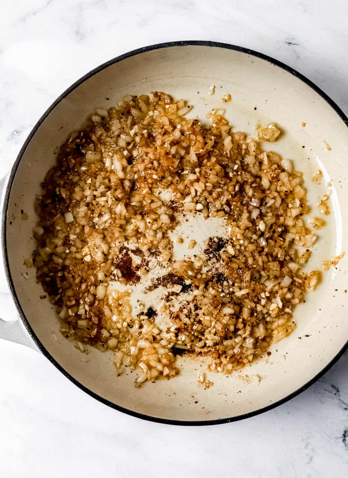 Diced onion and garlic in pan with oil and pan drippings. 