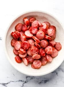 Overhead view of cooked sausage in a bowl.