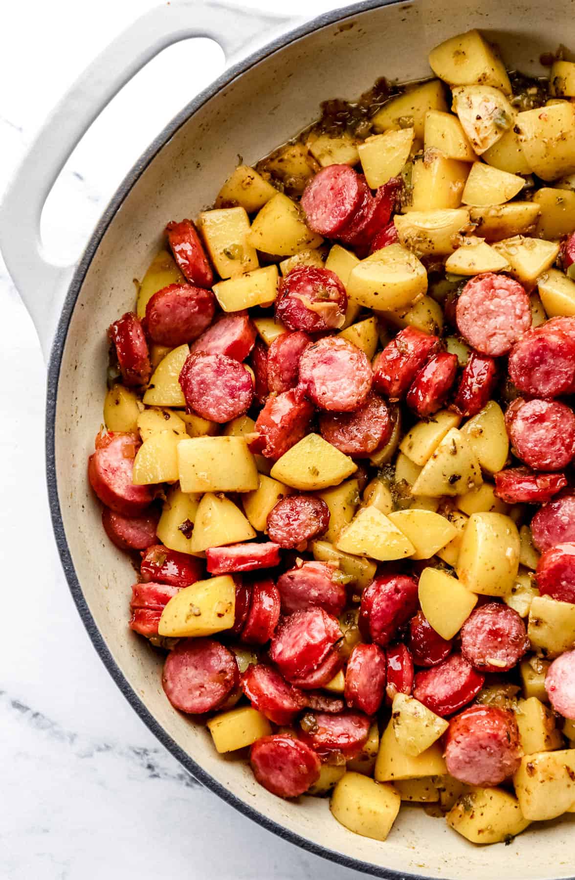 Sliced sausage added back to braiser along with the diced potatoes and other ingredients. 