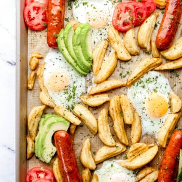 Close up overhead view of finished sheet pan breakfast bake with avocado and tomato added.