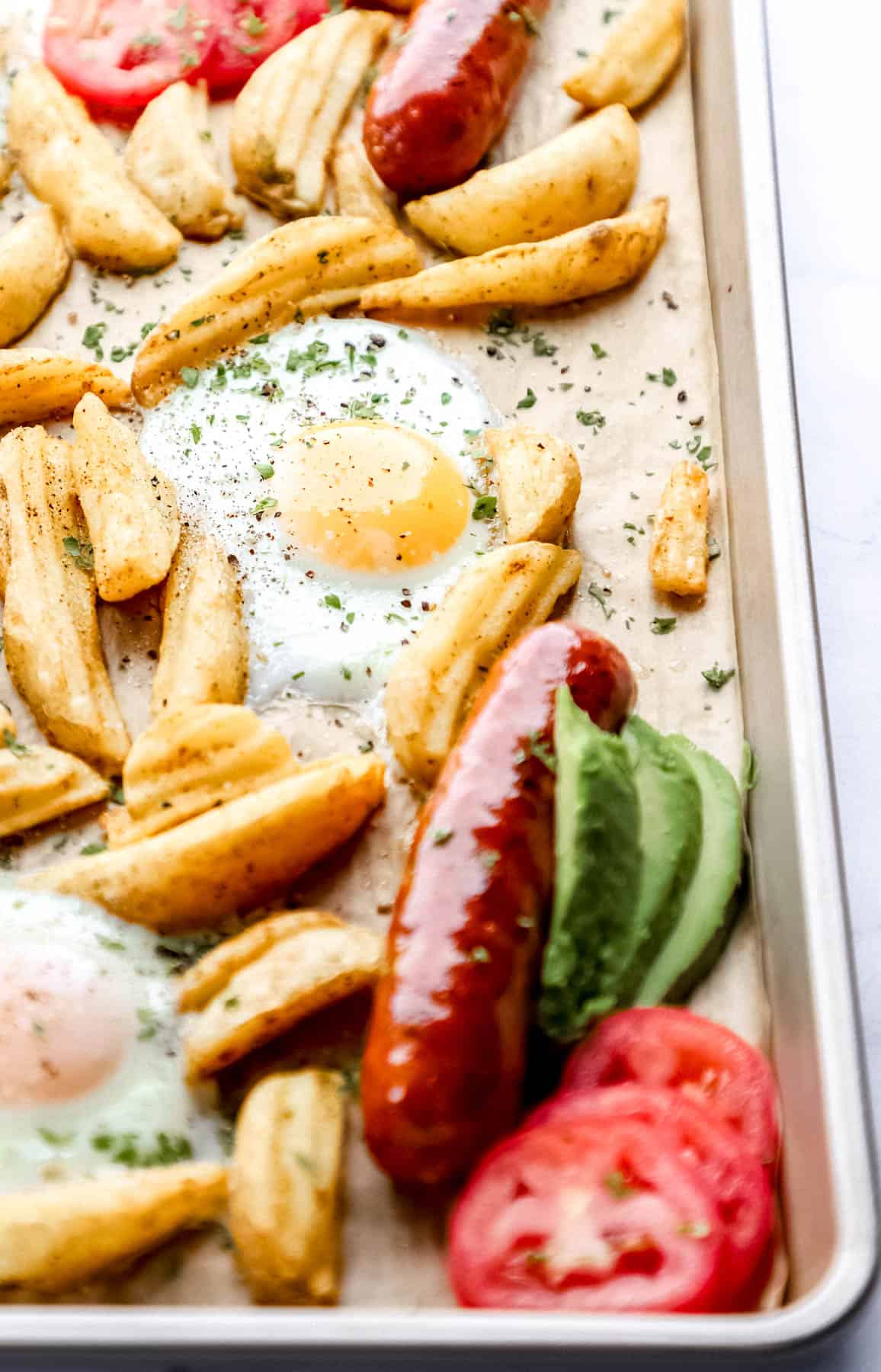 Close up front view of breakfast on parchment lined baking sheet. 