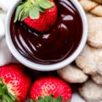 Close up of chocolate fondue in white bowl on dessert tray.
