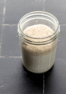 Close up view of jar with milk, yeast, and sugar in it.