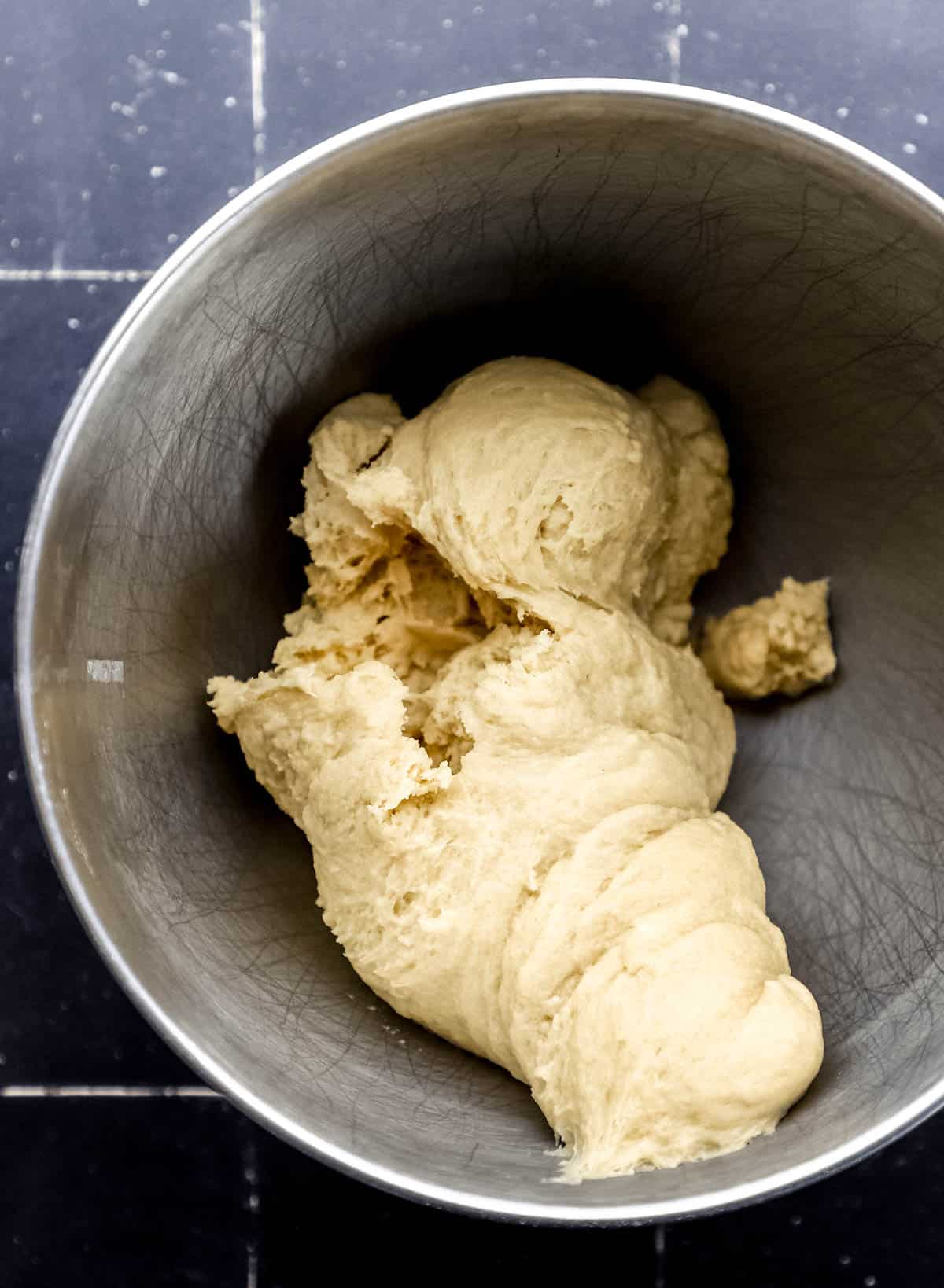 Soft cinnamon roll dough in stand mixer bowl. 