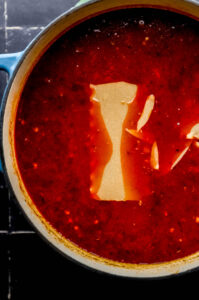 Lasagna noodles added to soup in large pot.