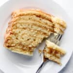 Overhead view of slice on cake on white plate with a fork in it.