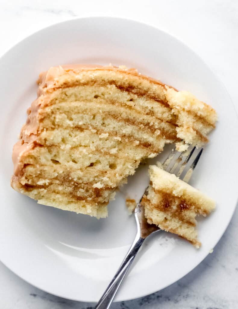 Overhead view of slice on cake on white plate with a fork in it.