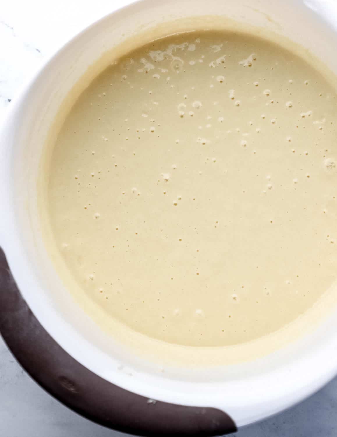 Cake ingredients combined in large white mixing bowl 