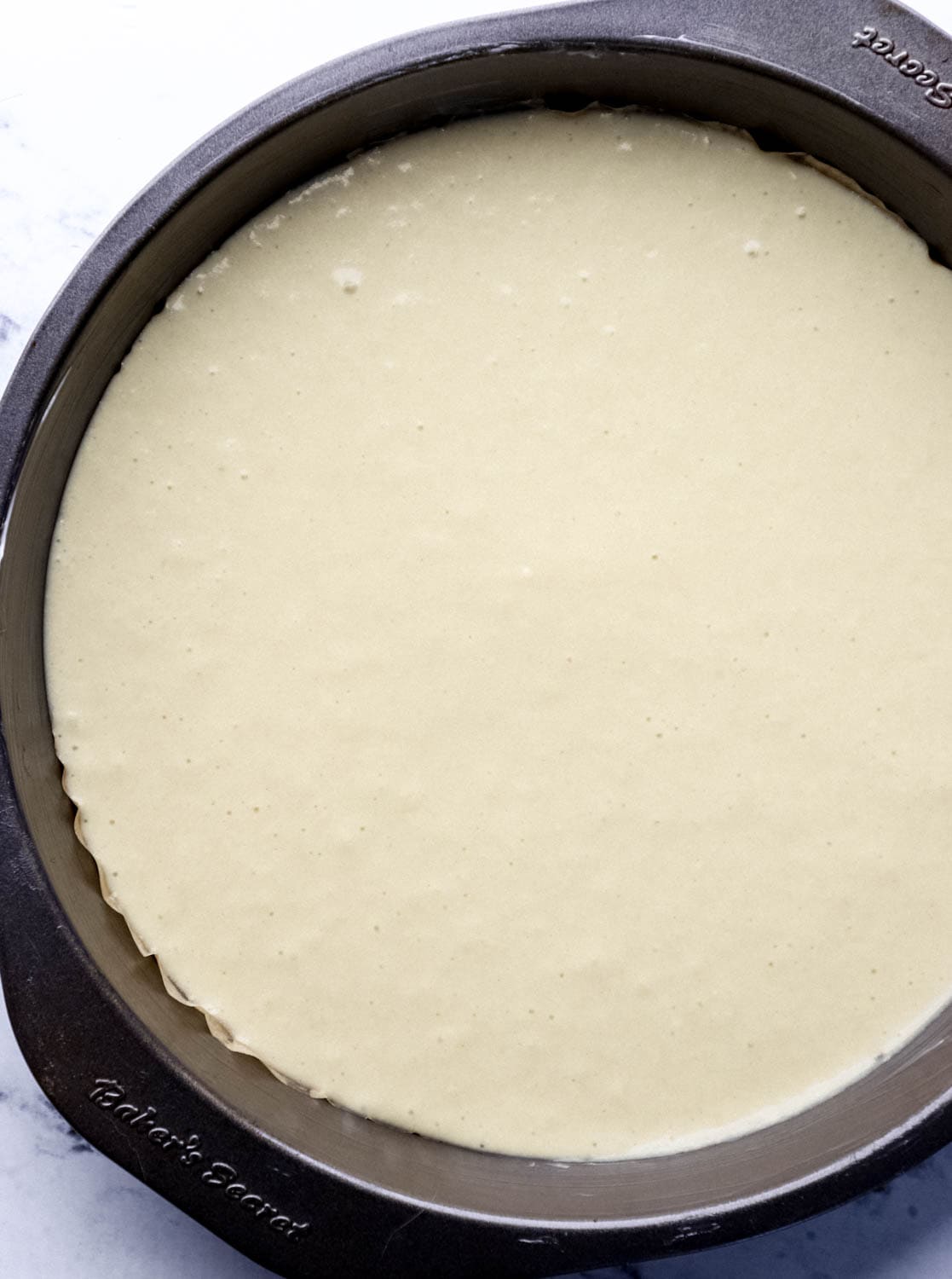 Cake mixture added to parchment lined baking pan.