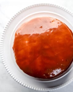 Overhead view of finished chocolate cake on cake plate.