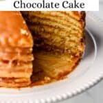 Close up side view of whole cake with slices cut out of it on white cake platter pin with text overlay.