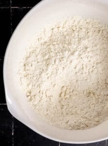Dry ingredients with butter in mixing bowl.