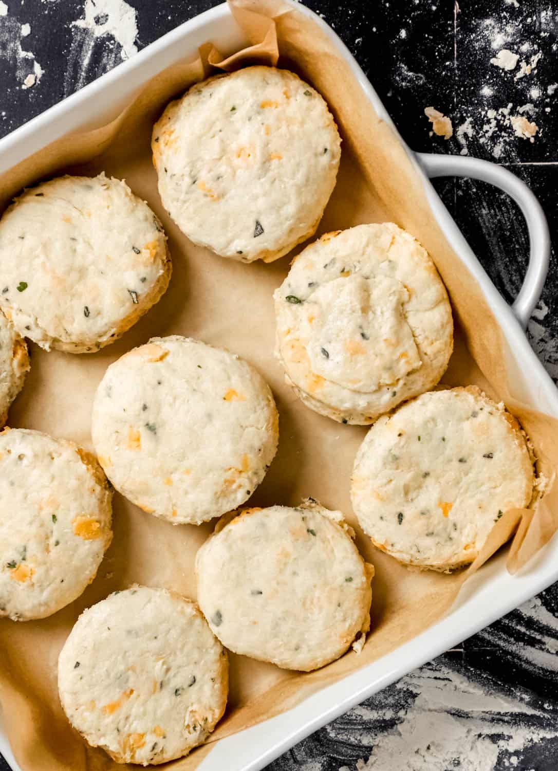 Biscuit dough added to parchment lined baking dish before baking. 