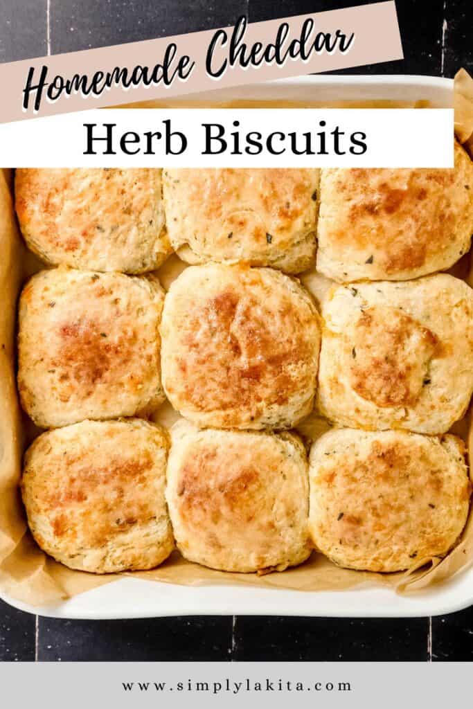 Overhead view of baked biscuits in parchment lined baking dish on black tile surface pin with text overlay.