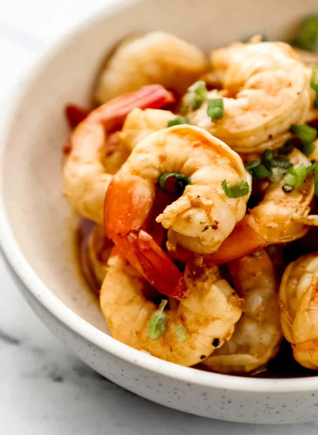 Close up side view of side view of cooked shrimp in a bowl. 