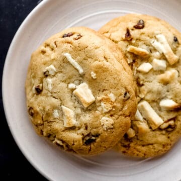 Overhead view of white plate with two cookies on it.