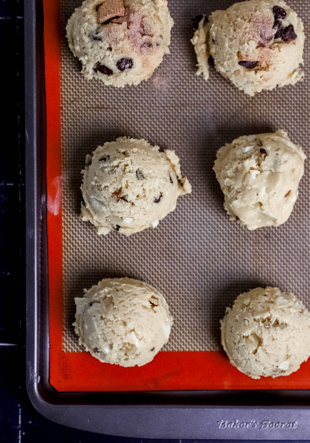 Overhead view of cookie dough on silplat lined baking sheet. 