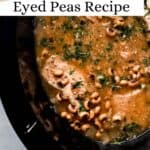 Overhead view of black slow cooker with finished black eyed peas and pork chops topped with freshly chopped parsley pin with text overlay.