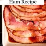 Overhead view of sliced ham in white baking dish pin with text overlay.