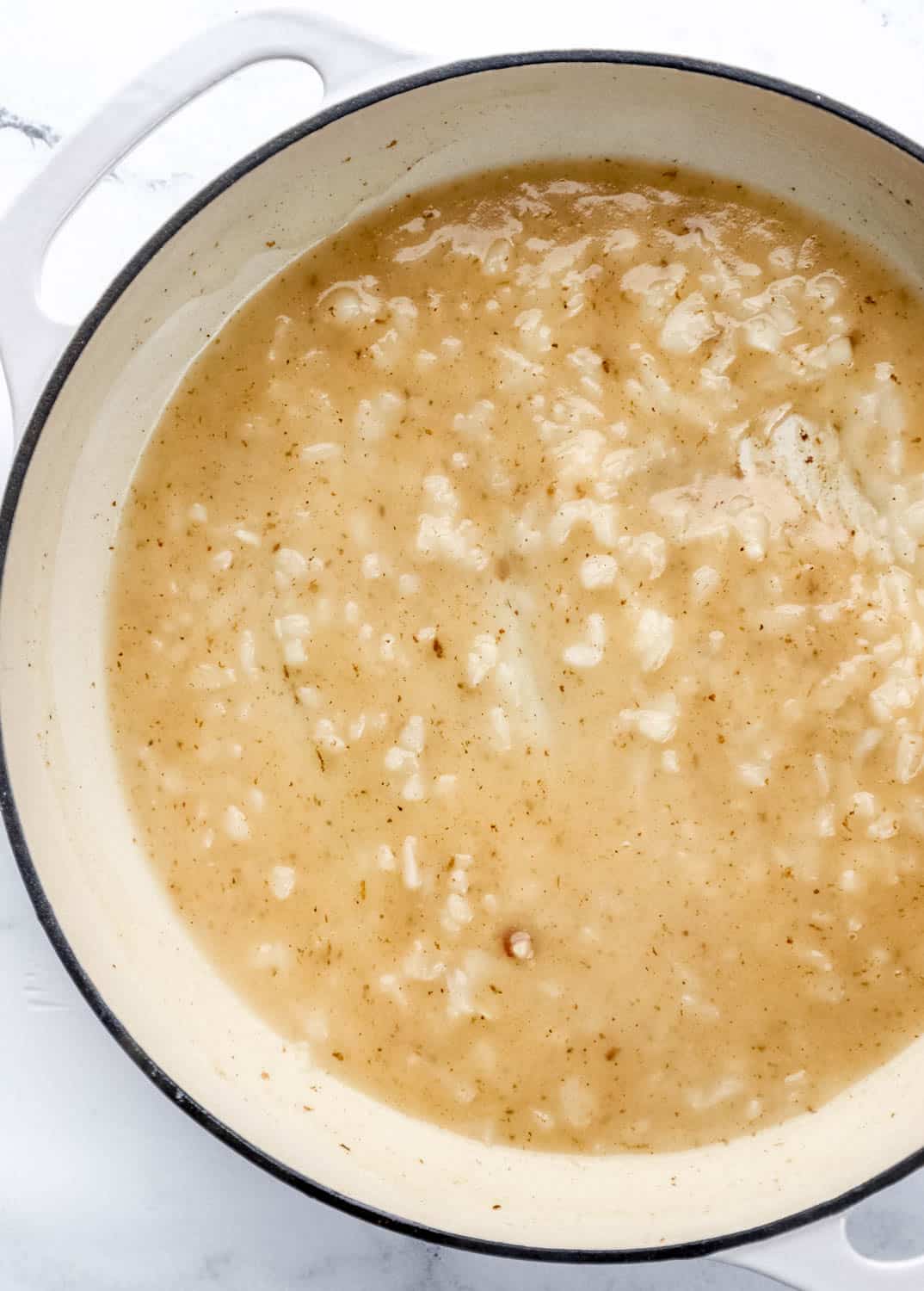 Overhead view of sweet and sour sauce in white braiser pan.  