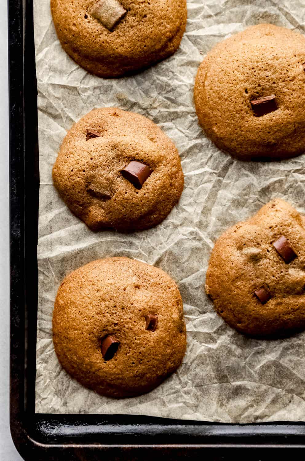 Overhead view of baked cookie on parchment lined baking sheet. 