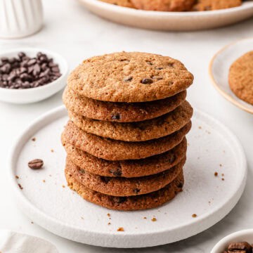 Close up side view of stack of cookies on white plate.