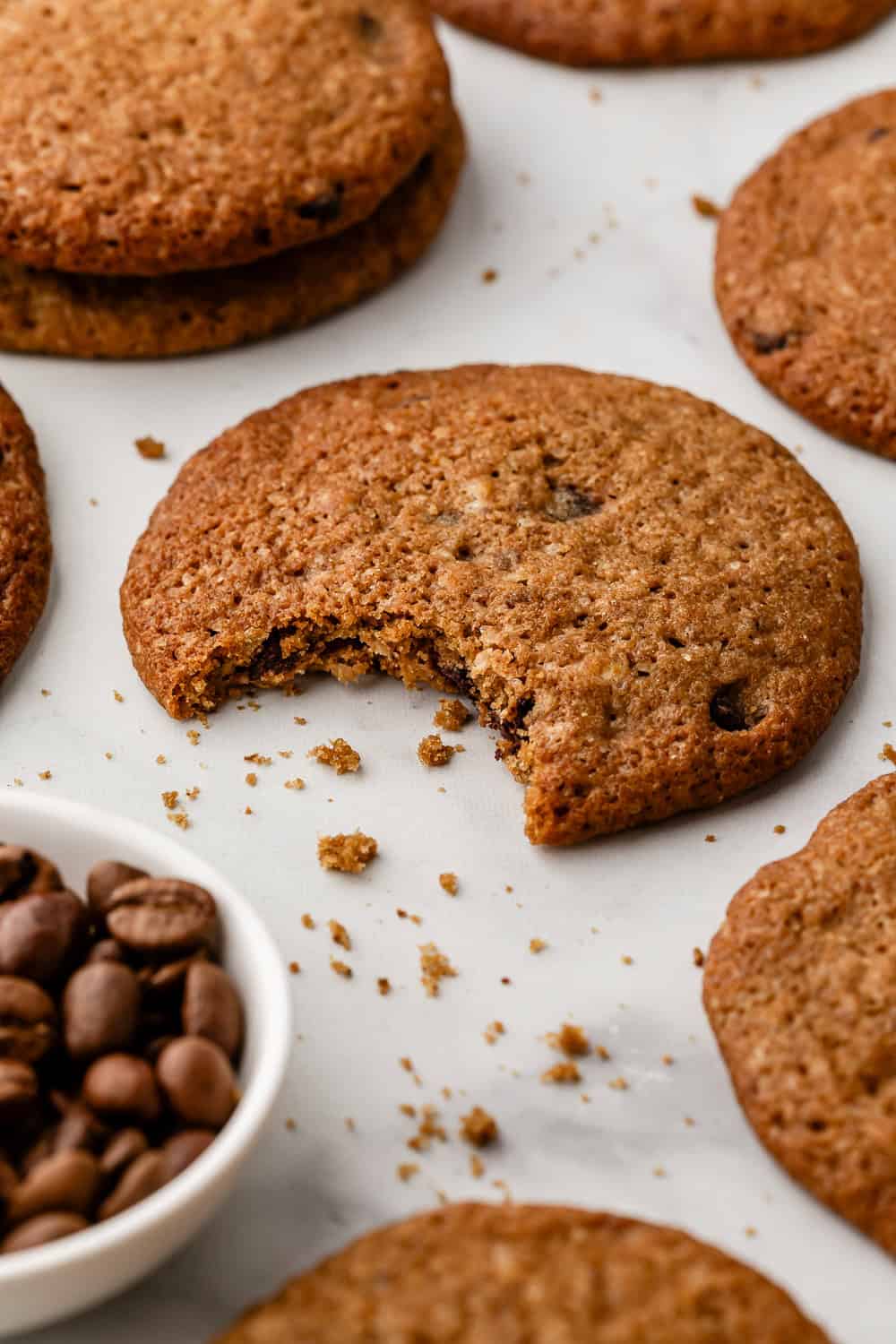 Close up view of cookie with a bite taken out of in surrounded by other cookies.